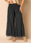 The Gia Pants from the Imagine Staple collection. These mesmerizing trousers&nbsp; with their romantic, full-length silhouette, delicately graced with a captivating mid-calf slit. Exquisitely crafted from soft silk, Gia is your go-to for elevating your night-time look. The expertly elasticated wide waistband promises all-day comfort and effortless style, allowing you to look and feel your most beautiful. Granite