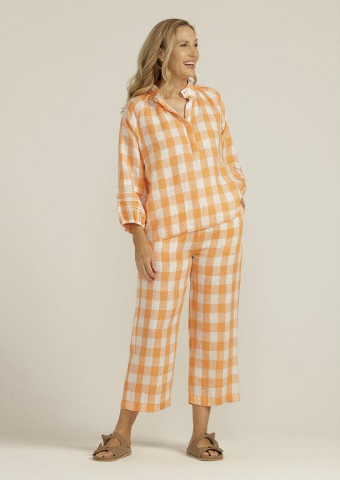 This beautiful 100% linen apricot gingham shirt has a full three quarter elastic finished raglan sleeve with pleats, which is gathered onto a band a the neck. It also features a  concealed button opening at front. It looks fabulous with the pants in same fabric.