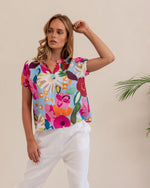 The vivid colours in this 100% linen top make is a summer standout.&nbsp; It's peasant style features an opening at the neck and a short elasticised sleeve.