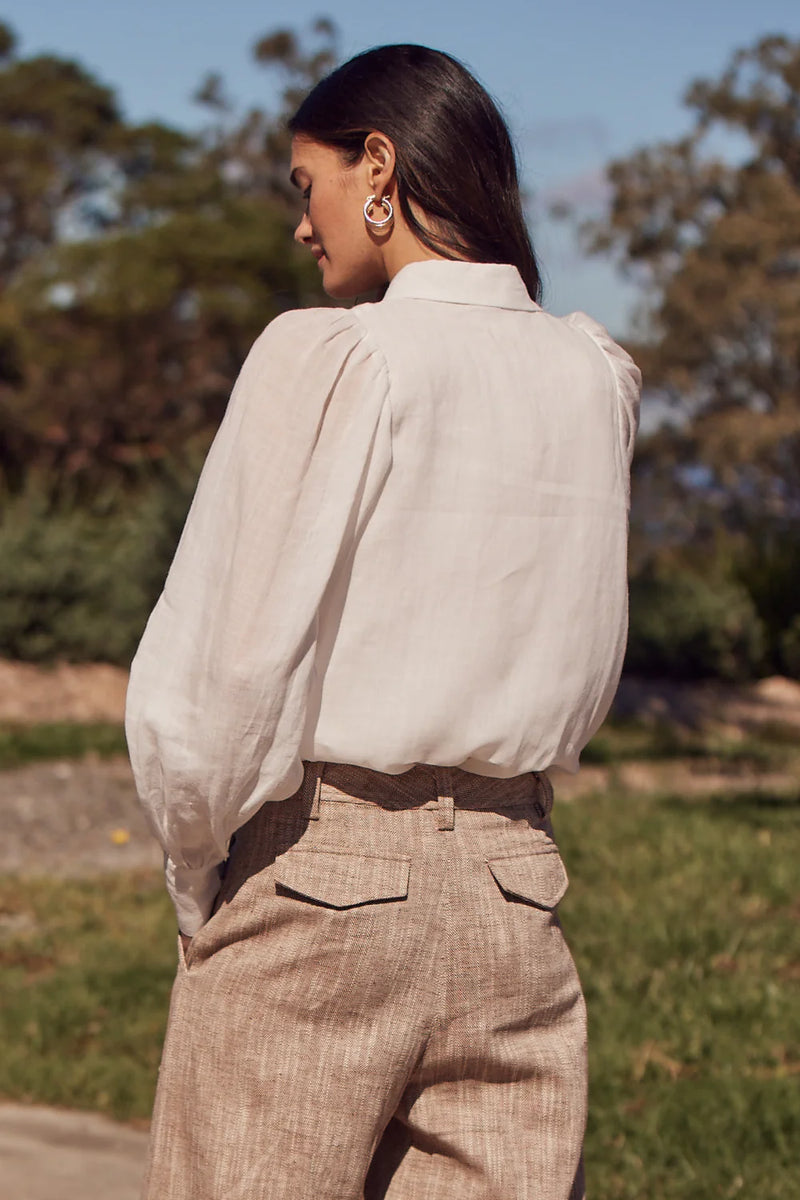 The Mirage Top merges soft femininity with effortless design. Crafted in lightweight ramie, it features a lined body and sheer, gathered blouson sleeves for a delicate contrast.&nbsp;

An inset shoulder seam flatters the silhouette, offering a piece that feels both classic and contemporary.