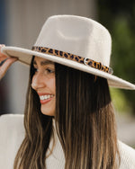 The Louenhide Montego Felt Hat is the perfect accessory for anyone who wants to stay warm and stylish during the colder months. Made from 100% wool, this hat features a medium width brim that provides excellent coverage, while the contrasting leopard print, vegan leather hat band adds a touch of elegance and texture. 