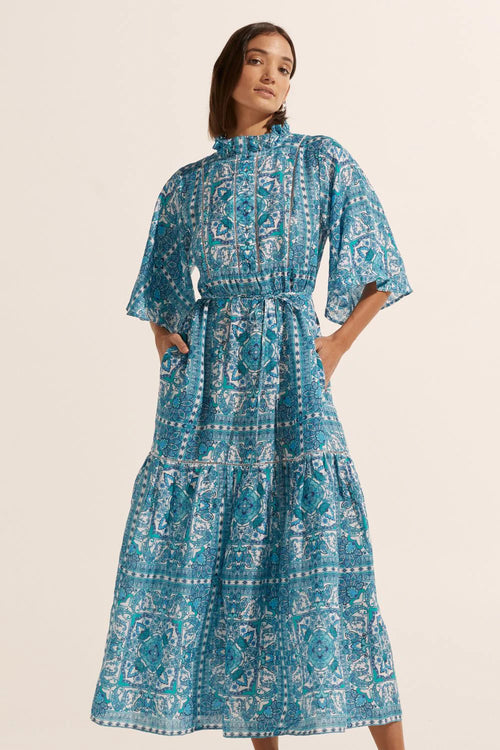 The Navigate dress, an array of aquatic inspired hues harmonise in this vintage-inspired print. A blend of floral motifs and geometric shapes create a Moroccan inspired ambiance in this signature print. Thoughtfully constructed with our signature ruffle neckline, delicate covered buttons and soft flutter sleeve.