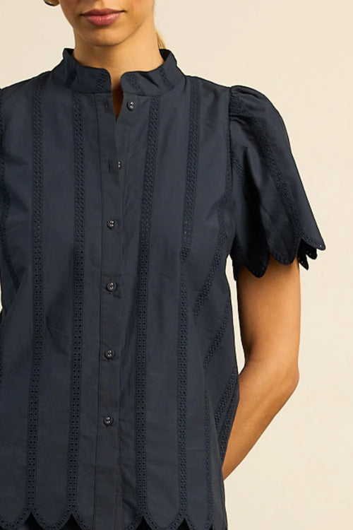 the pier top is elevated with cotton broderie that finishes in scalloped cuffs and a scalloped hem. a high neck-stand lends structure, while colour-matched fabric buttons elevated with classic shirt with a twist. designed for versatility, it pairs seamlessly with the harbour pant for an elegant seasonal look.

100% cotton poplin
Cotton broderie with scalloped cuffs and hem
high neck-stand for refined structure
fabric-covered buttons adds polish
pairs perfectly with the harbour pant