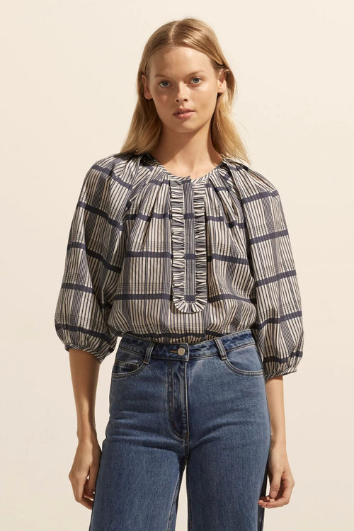 Soft gathering off the neckline creates a curved and feminine aesthetic in this piece. Neat ruffles frame the ¾ placket providing poise and polish.    Colour: Ink/Porcelain Check