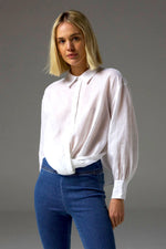 The Sidle Top is a masterclass in relaxed elegance, designed to flatter with its waist-length cut and folded hemline. A curved rear hem adds soft movement, while the rear gathered yoke introduces subtle volume for an off-the-body silhouette.&nbsp;

Full-length sleeves and a button-through front bring timeless versatility, making it perfect for effortless styling, whether worn tucked or untucked.