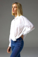 The Sidle Top is a masterclass in relaxed elegance, designed to flatter with its waist-length cut and folded hemline. A curved rear hem adds soft movement, while the rear gathered yoke introduces subtle volume for an off-the-body silhouette.&nbsp;

Full-length sleeves and a button-through front bring timeless versatility, making it perfect for effortless styling, whether worn tucked or untucked.