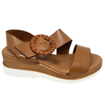 Made in Spain, this soft unlined leather wedged sandal has an angled strap across the instep finishing in a round rattan looking buckle, a memory foam insole and a white sole. 