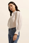 The Swoon top delivers a romantic and artisanal option that has feminine details at its core. A full-length sleeve is gathered at the wrist and finished with a ruffle. Another ruffled edge creates a flattering neckline and front detail. Horizontal ladder lace brings an element of classic elegance to this piece. 