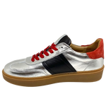 This cool little leather sneaker has a gum sole and silver outer with black side stripes, red suede at the heel land red laces.