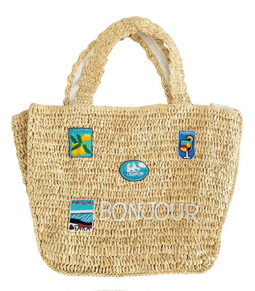 This large raffia tote bag has two handles and measures 36cm x 32cm x 14cm. It has a magnetic clip closure and features "Bonjour" and other mofits beaded on the front.