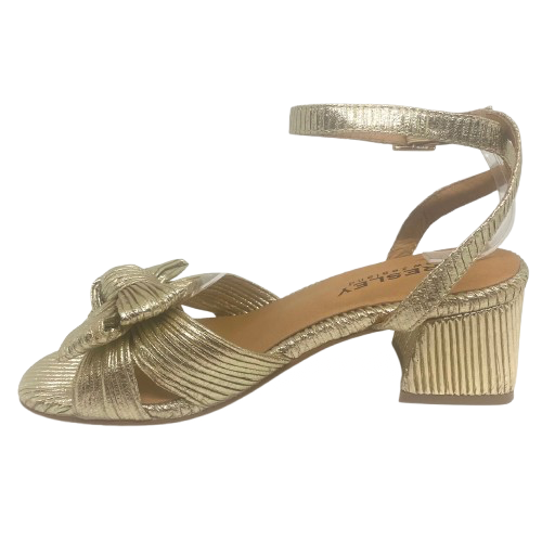 Gold high-heeled sandal with a knot design on a white background