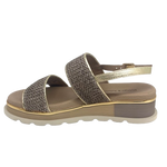 A low summer wedge by Django &amp; Juliette in mocha raffia with a gold trim. It features two bands across the foot and a gold leather back strap. A neutral but interesting and comfortable summer sandal.
