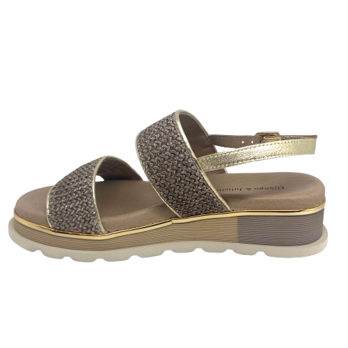 A low summer wedge by Django &amp; Juliette in mocha raffia with a gold trim. It features two bands across the foot and a gold leather back strap. A neutral but interesting and comfortable summer sandal.