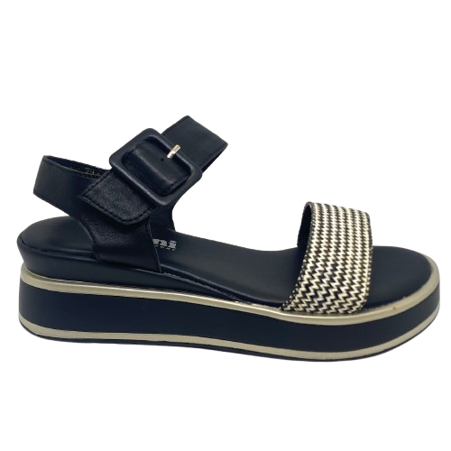 This low flatform wedge in black has a weave of both black and white in the front strap making it a versatile and interesting little sandal. A wide Y back gives plenty of support and is finished with a leather covered buckle. Made by Cassini.
