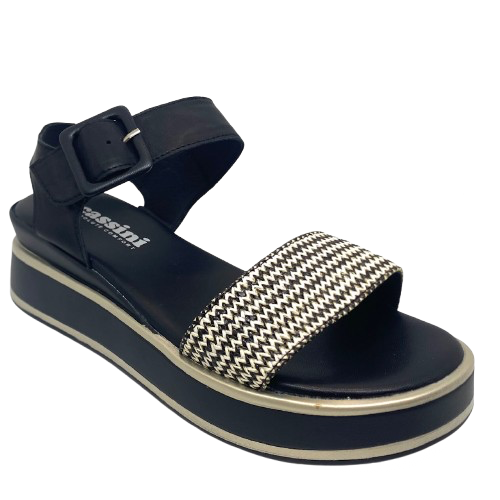 This low flatform wedge in black has a weave of both black and white in the front strap making it a versatile and interesting little sandal. A wide Y back gives plenty of support and is finished with a leather covered buckle. Made by Cassini.