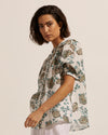 This simple yet elegant piece is a study in relaxed yet feminine dressing. The button-through style has slight gathering off the front shoulders and rear yoke creating an effortless aesthetic. The Virtue is brought to life with this signature print of beautiful botanicals.   A subtle blouson sleeve, cuffed just above the elbows is finished with a neat elastic band. The body shape offers a neat fit making this piece the perfect spring companion.  composition: 100% ramie