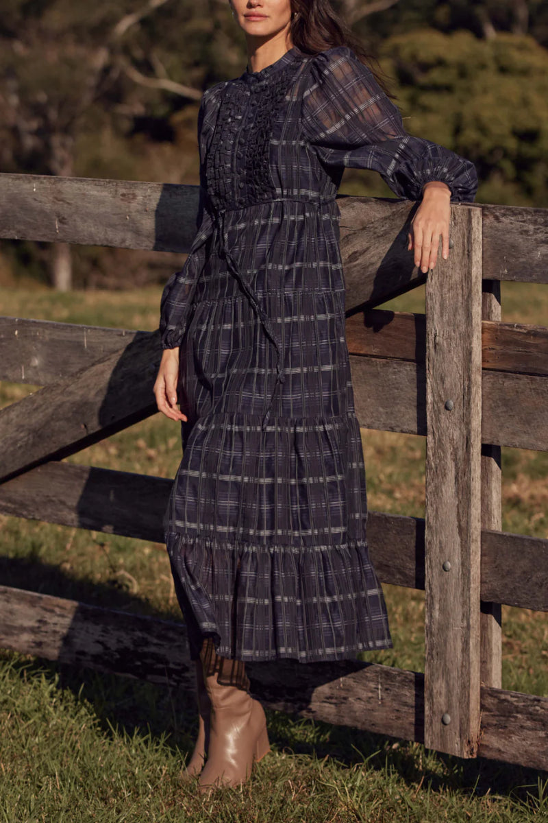 90% cotton 10% silk
Lightweight, breathable fabric for year-round wear
Ink Black Check print for a modern, monochrome aesthetic
Ruffle-trimmed bodice and tiered skirt for soft femininity
Self-tie belt for adjustable styling
Designed to transition seamlessly through the seasons