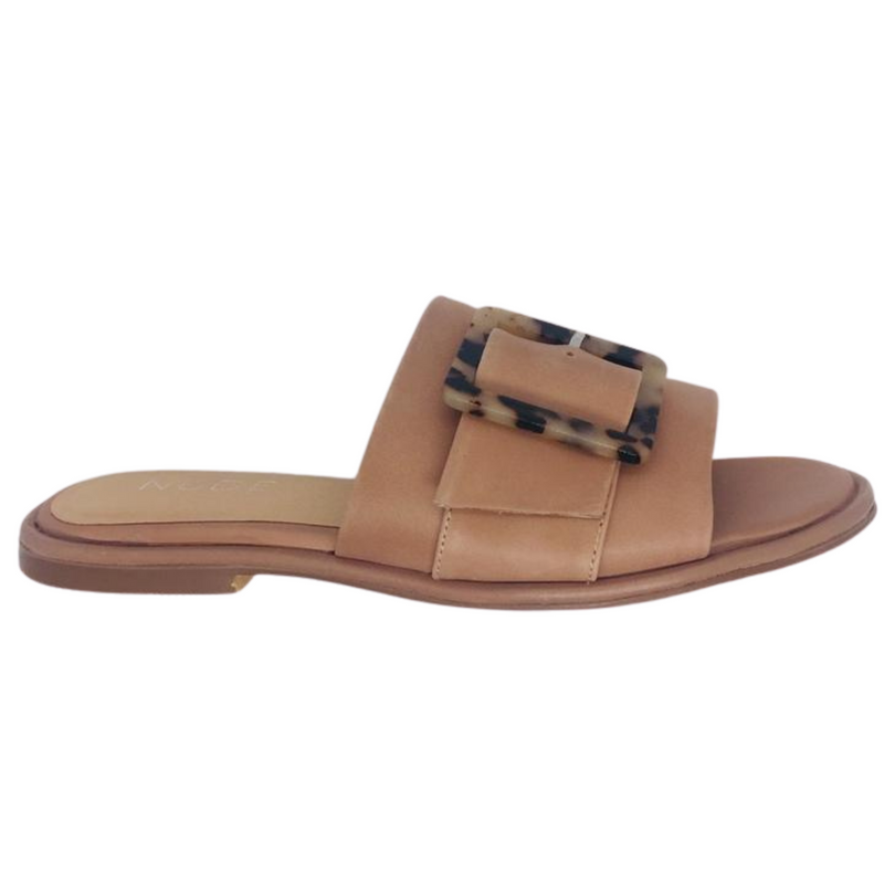 Flat summer slide in natural leather featuring a wide strap across the foot and a gorgeous tortoise shell buckle.