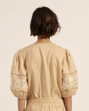 A relaxed fit and light  weight linen cut a cool and comfortable line, while floral motif embroidery lends a touch offemininity. A soft shade of cream is complemented with caramel-hued motifs that adorn the billowing sleeves. Covered buttons finish this feminine but highly wearable piece. 100% linen. Soft vanilla and caramel tones. Covered button detail.