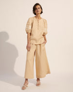 A relaxed fit and light  weight linen cut a cool and comfortable line, while floral motif embroidery lends a touch offemininity. A soft shade of cream is complemented with caramel-hued motifs that adorn the billowing sleeves. Covered buttons finish this feminine but highly wearable piece. 100% linen. Soft vanilla and caramel tones. Covered button detail.