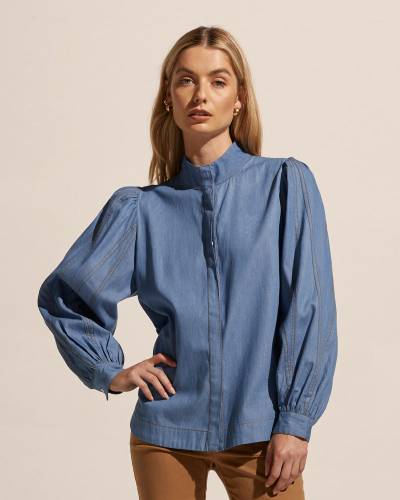 A precise and defined piece, the Oblige shirt aspires to new heights. Fresh and contemporary the seamed and top-stitched sleeve provides drama with beautiful detail. This detail is balanced by a clean concealed button placket and scooped hemline. Contrasting top-stitch seal the deal on this stunning wardrobe stable.    