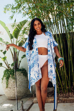 Made by Possi of softly flowing 100% viscose this beautiful kimono will have you feeling cool, comfortable and elegant on your next vacation. This Mediterranean print fabric is available in red or blue with a matching striped tie belt.  Sizes  -  S/M  L/XL