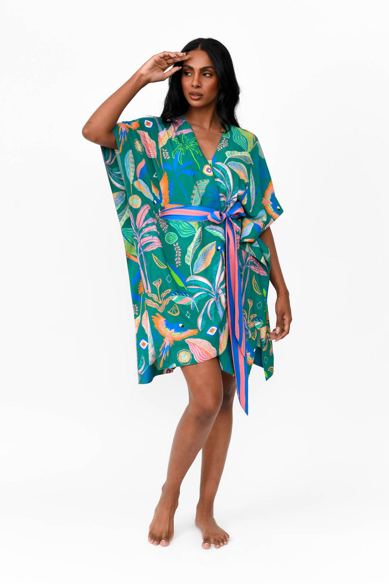 Made by Possi of softly flowing 100% viscose this beautiful kimono will have you feeling cool, comfortable and elegant on your next vacation. This tropical print fabric is available in orange or emerald with a contrasting striped tie belt.  Sizes  -  S/M  L/XL